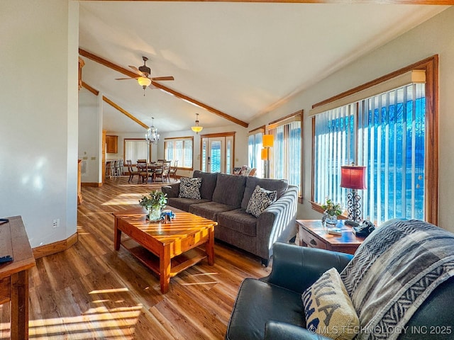 living room featuring high vaulted ceiling, wood-type flooring, beam ceiling, and ceiling fan with notable chandelier