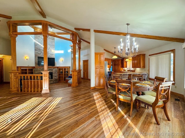 dining area featuring a chandelier, light hardwood / wood-style floors, decorative columns, and vaulted ceiling with beams