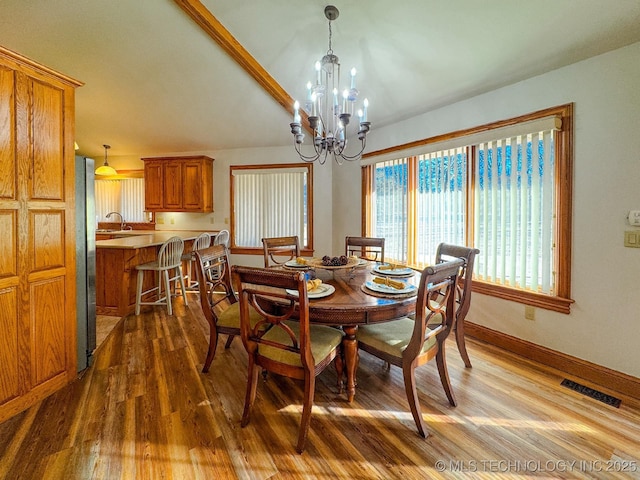 dining space featuring wood-type flooring and a notable chandelier