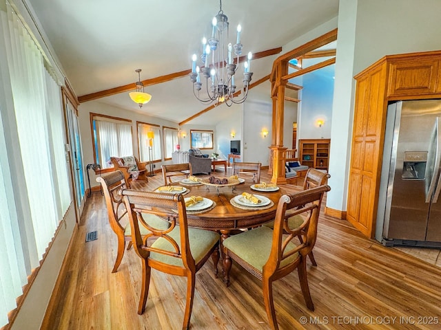 dining room with lofted ceiling, a notable chandelier, and light hardwood / wood-style floors