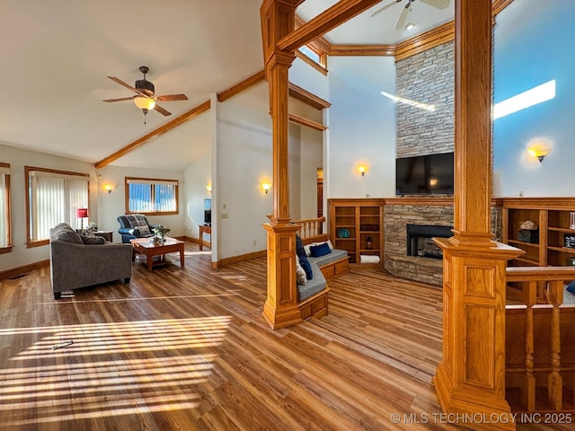 living room with hardwood / wood-style floors, high vaulted ceiling, ceiling fan, and ornate columns