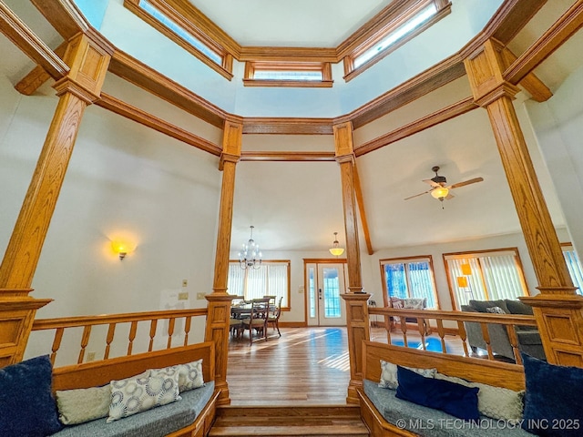 living room featuring a high ceiling, ceiling fan with notable chandelier, and hardwood / wood-style floors