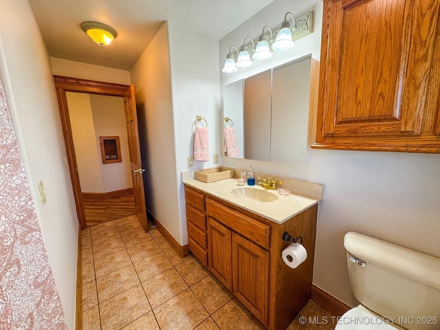 bathroom with tile patterned flooring, vanity, and toilet