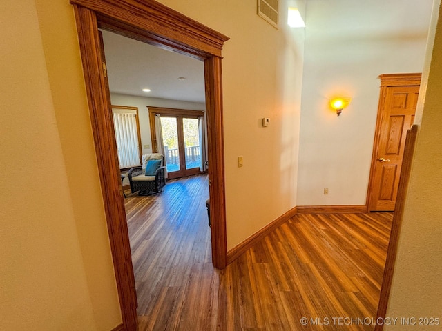 corridor with french doors and dark wood-type flooring