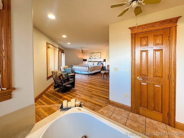 bathroom featuring tile patterned flooring, ceiling fan, and a bathtub