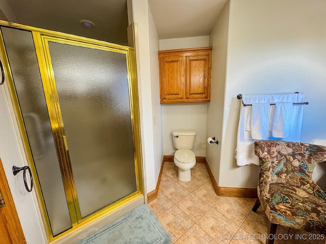 bathroom featuring a shower with shower door and toilet