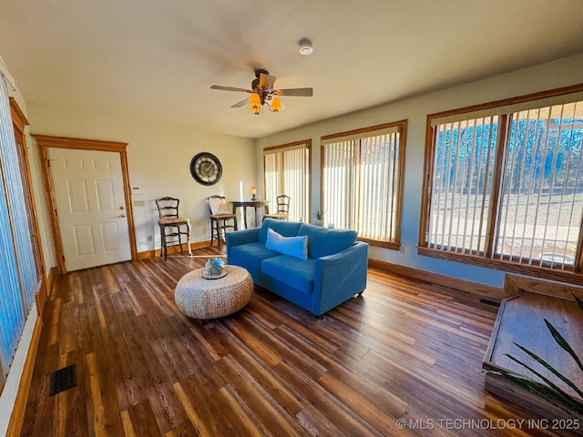 living room with dark wood-type flooring and ceiling fan