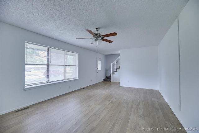 interior space featuring ceiling fan, a textured ceiling, and light hardwood / wood-style flooring