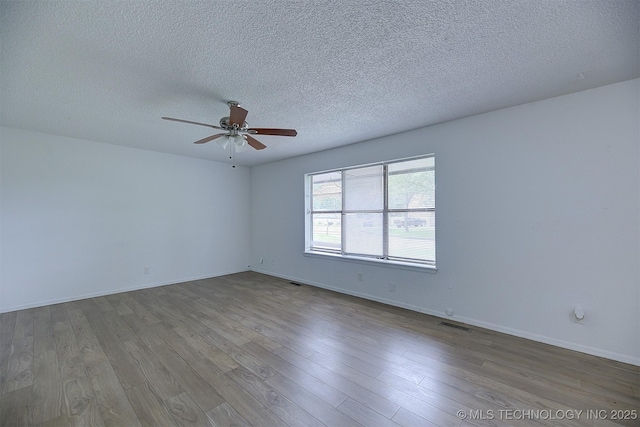 empty room with hardwood / wood-style flooring, ceiling fan, and a textured ceiling