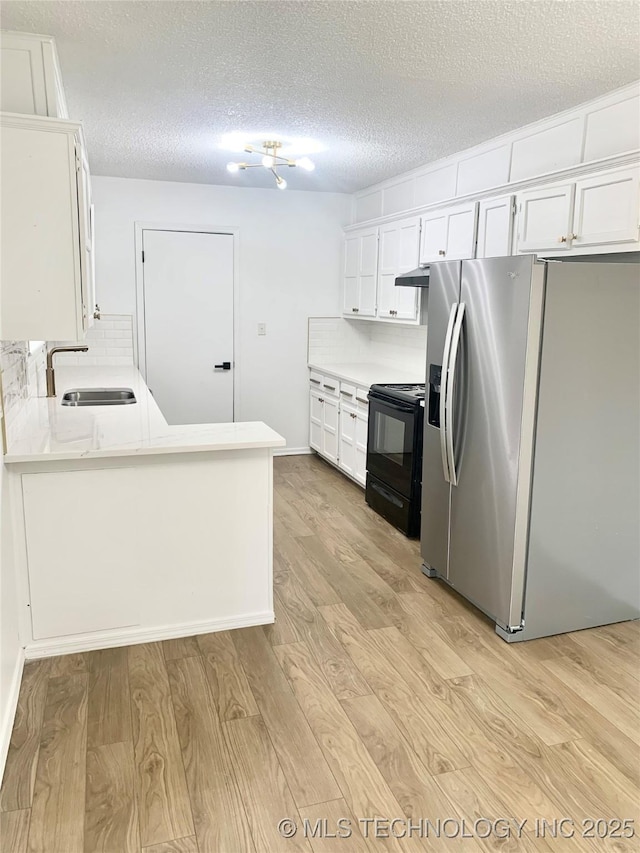 kitchen with white cabinetry, sink, black range with electric cooktop, stainless steel refrigerator with ice dispenser, and kitchen peninsula