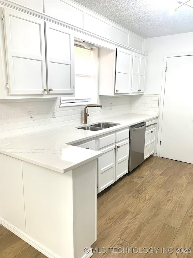 kitchen featuring dishwasher, wood-type flooring, white cabinetry, and sink