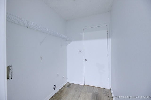 laundry area featuring hookup for a washing machine, a textured ceiling, and hardwood / wood-style flooring