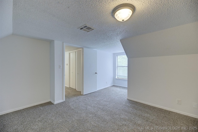 bonus room with carpet, a textured ceiling, and vaulted ceiling