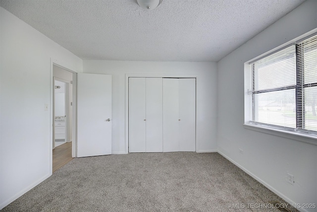 unfurnished bedroom with light colored carpet, a textured ceiling, and a closet