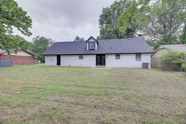 back of property featuring french doors, central AC, and a lawn