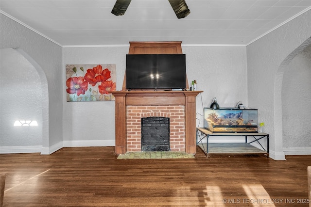 living room with dark hardwood / wood-style flooring, ornamental molding, and a fireplace