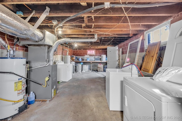 basement featuring heating unit, washer and dryer, and water heater