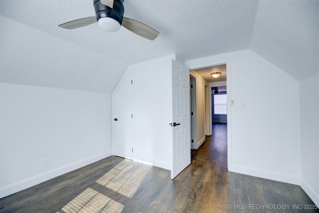 bonus room with ceiling fan, dark hardwood / wood-style floors, a textured ceiling, and vaulted ceiling