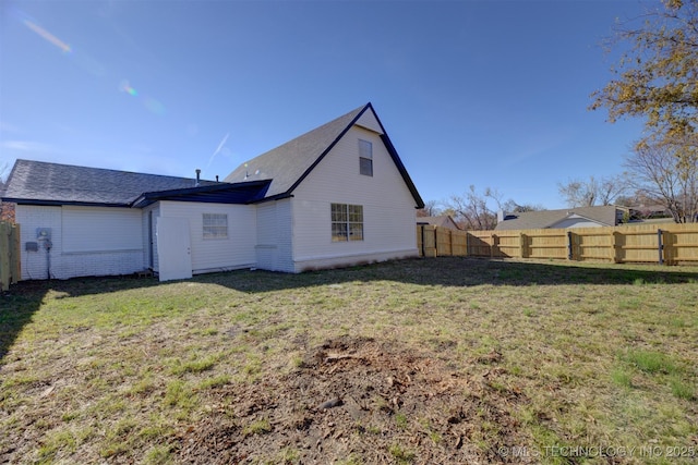 rear view of property featuring a yard