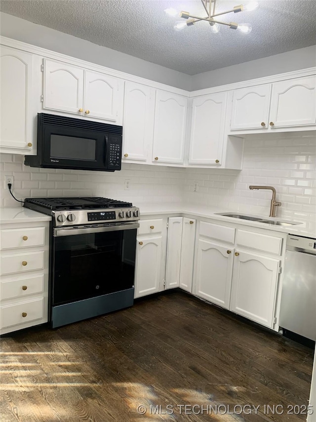 kitchen with dark hardwood / wood-style flooring, backsplash, stainless steel appliances, sink, and white cabinets