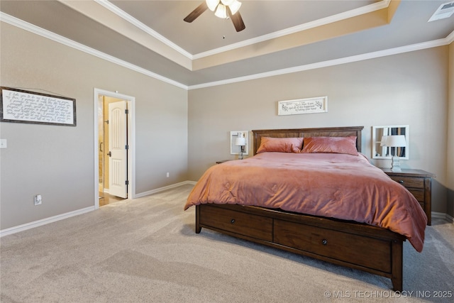 bedroom with light colored carpet, a raised ceiling, ceiling fan, and ensuite bathroom