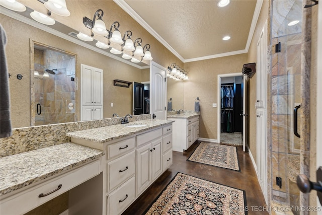 bathroom with a textured ceiling, vanity, an enclosed shower, and wood-type flooring