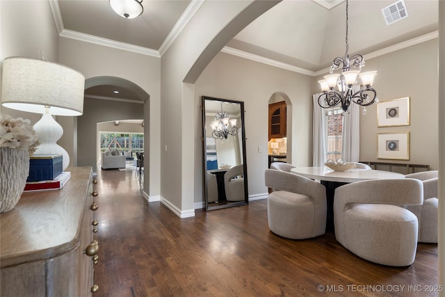 dining room with dark hardwood / wood-style floors, crown molding, and a chandelier