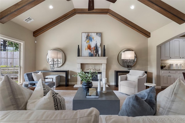 living room with vaulted ceiling with beams and light hardwood / wood-style floors