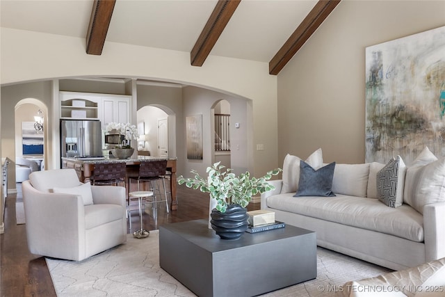 living room with vaulted ceiling with beams and light hardwood / wood-style floors