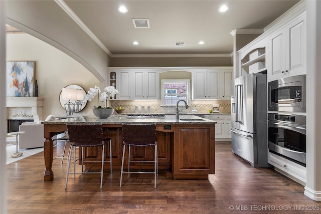 kitchen featuring white cabinets, decorative backsplash, light stone countertops, and stainless steel appliances