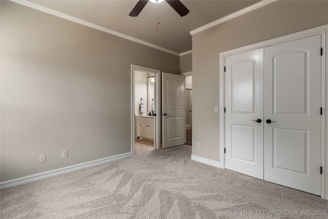 unfurnished bedroom with ensuite bath, ceiling fan, crown molding, light carpet, and a closet