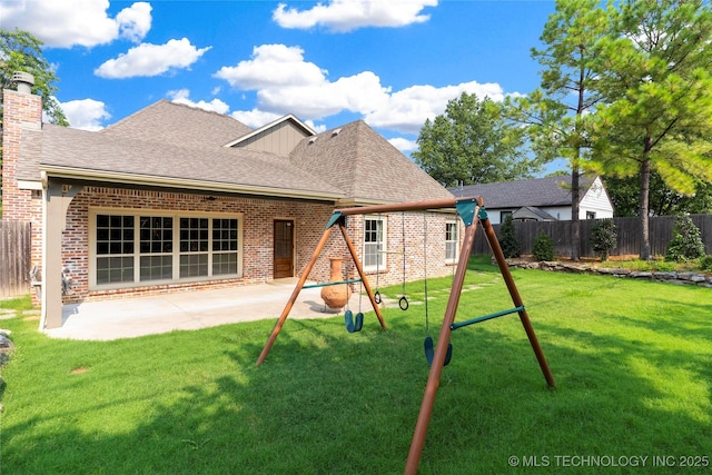 back of property with a playground, a yard, and a patio