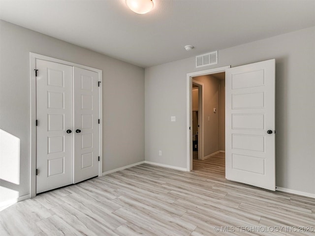 unfurnished bedroom with light hardwood / wood-style floors and a closet