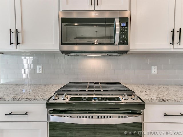 kitchen featuring light stone countertops, appliances with stainless steel finishes, backsplash, and white cabinetry