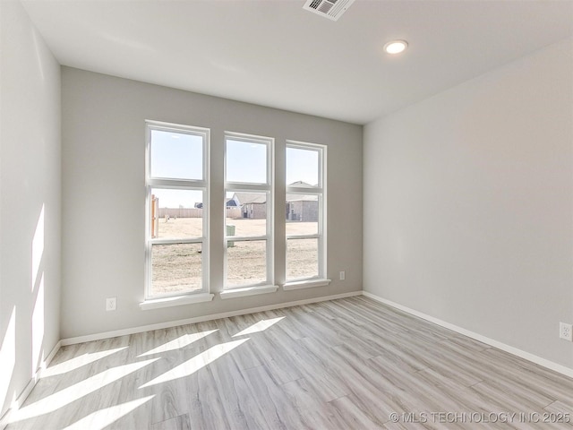 empty room featuring light hardwood / wood-style flooring and a wealth of natural light