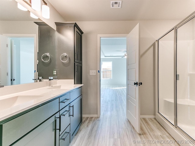 bathroom with ceiling fan, wood-type flooring, walk in shower, and vanity