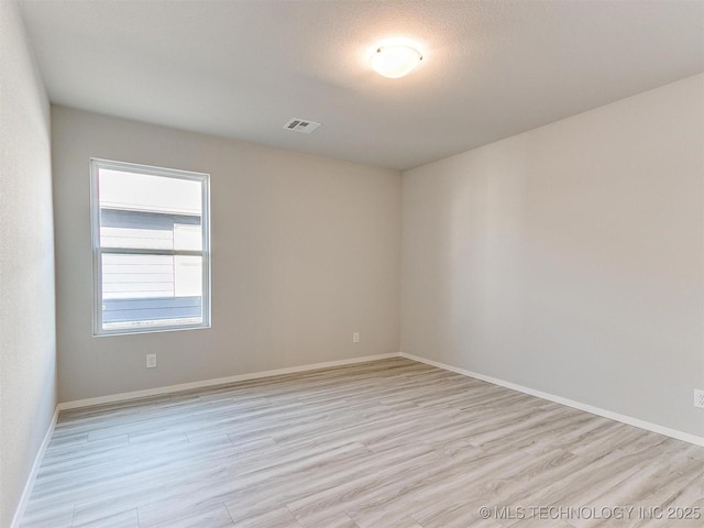 unfurnished room with light hardwood / wood-style floors and a textured ceiling