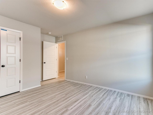 unfurnished bedroom with a textured ceiling and light hardwood / wood-style flooring