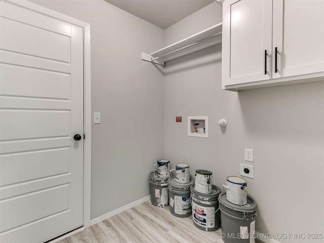 laundry area featuring washer hookup, electric dryer hookup, light hardwood / wood-style floors, and cabinets