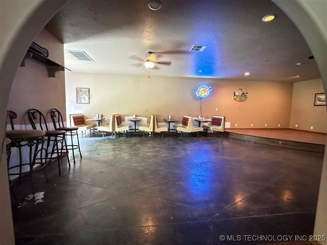 interior space with ceiling fan and a textured ceiling