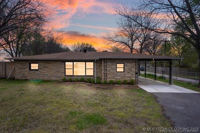 view of front facade featuring a lawn and a carport