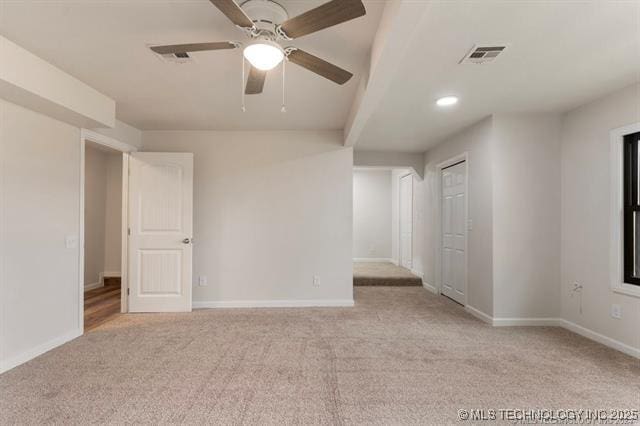 carpeted spare room featuring ceiling fan