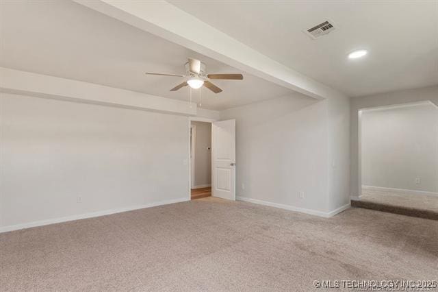 empty room with beamed ceiling, ceiling fan, and light colored carpet