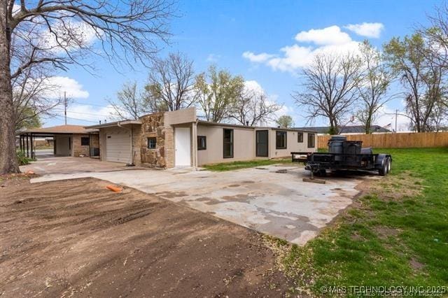 view of front of home with a garage, a front yard, and a carport