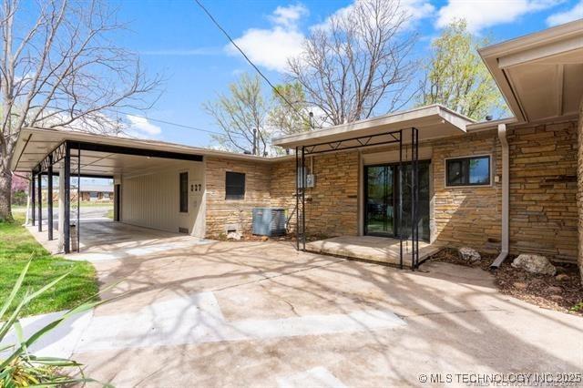 back of property with a carport and central air condition unit