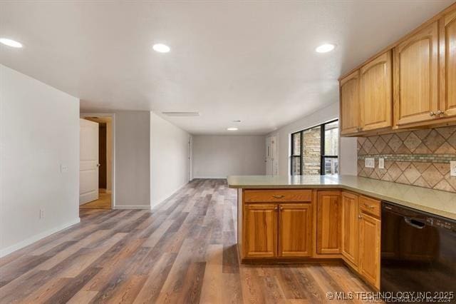 kitchen with decorative backsplash, kitchen peninsula, black dishwasher, and dark wood-type flooring