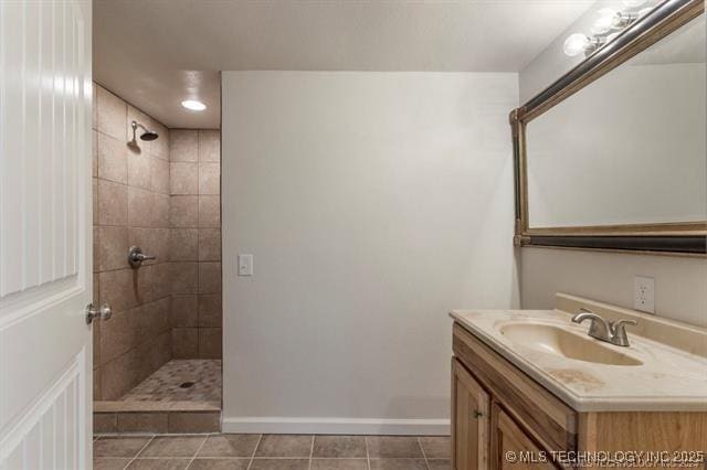 bathroom featuring a tile shower, tile patterned flooring, and vanity