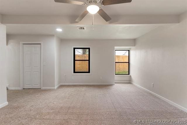 carpeted empty room featuring beam ceiling and ceiling fan