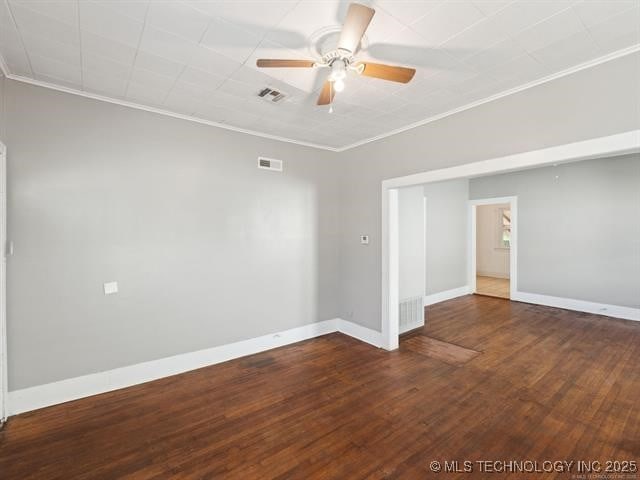 unfurnished room with ceiling fan, ornamental molding, and dark wood-type flooring