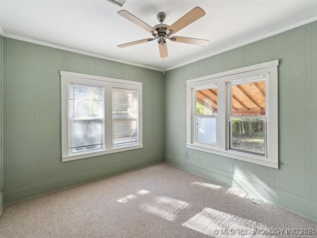 spare room with ceiling fan, light colored carpet, and ornamental molding